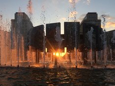 Das Bild zeigt den Brunnen am Strausberger Platz in einer Nahaufnahme mit Blick in Richtung Alexanderplatz bei Sonnenuntergang.